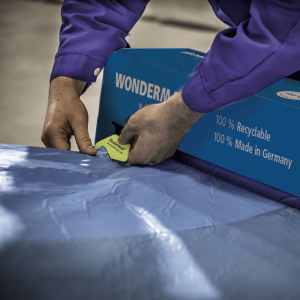 Technician cutting masking film with clear contour visibility