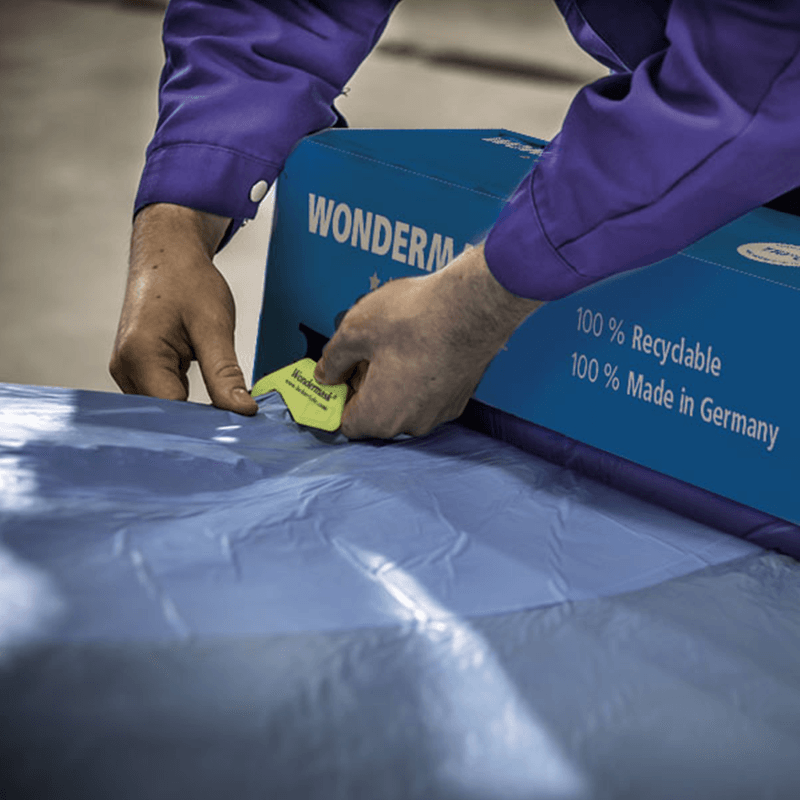 Technician cutting masking film with clear contour visibility