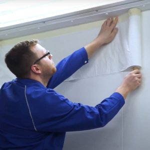 318631 pre-taped spray booth wall protection film being installed on booth walls