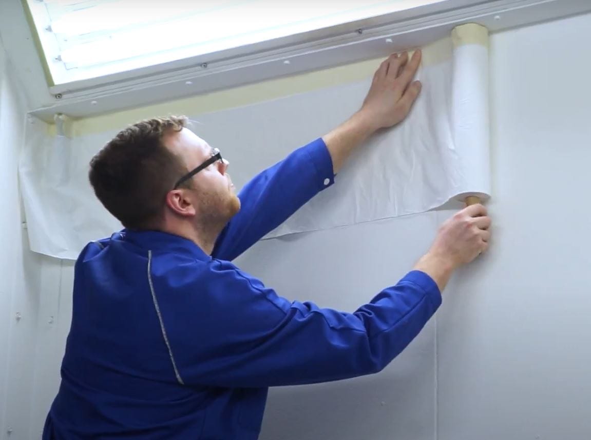 318631 pre-taped spray booth wall protection film being installed on booth walls