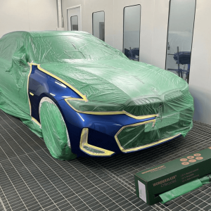 recycled automotive masking film covering blue car in spray booth