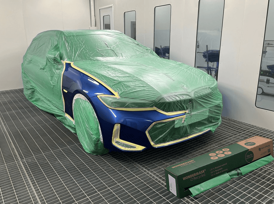 recycled automotive masking film covering blue car in spray booth