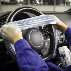 Disposable steering wheel protection covers in dispenser box for automotive workshops