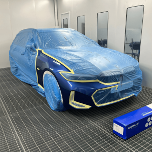 Car covered with water resistant masking film during painting