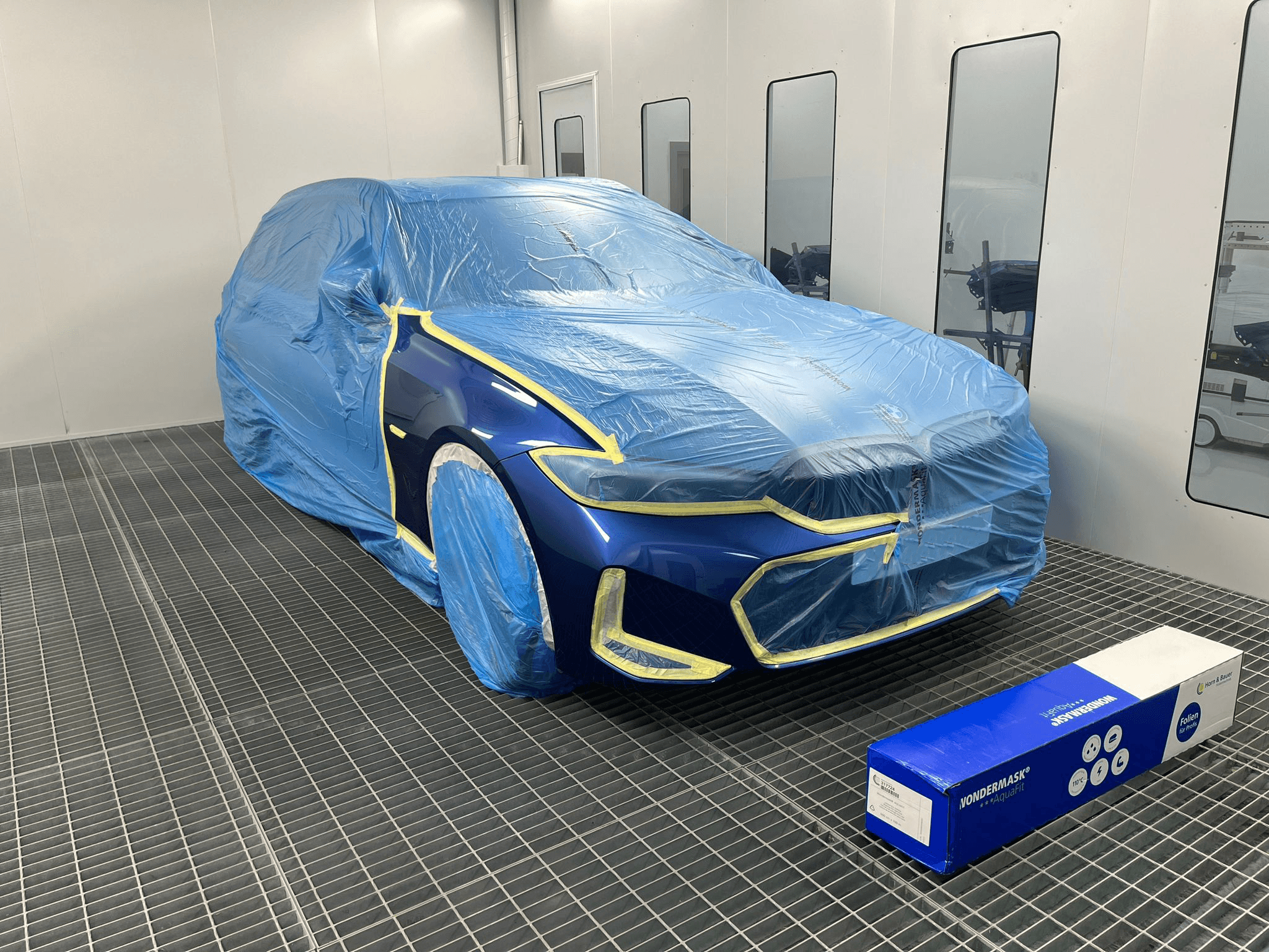 Car covered with water resistant masking film during painting