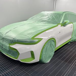 recycled automotive masking film covering white car in spray booth