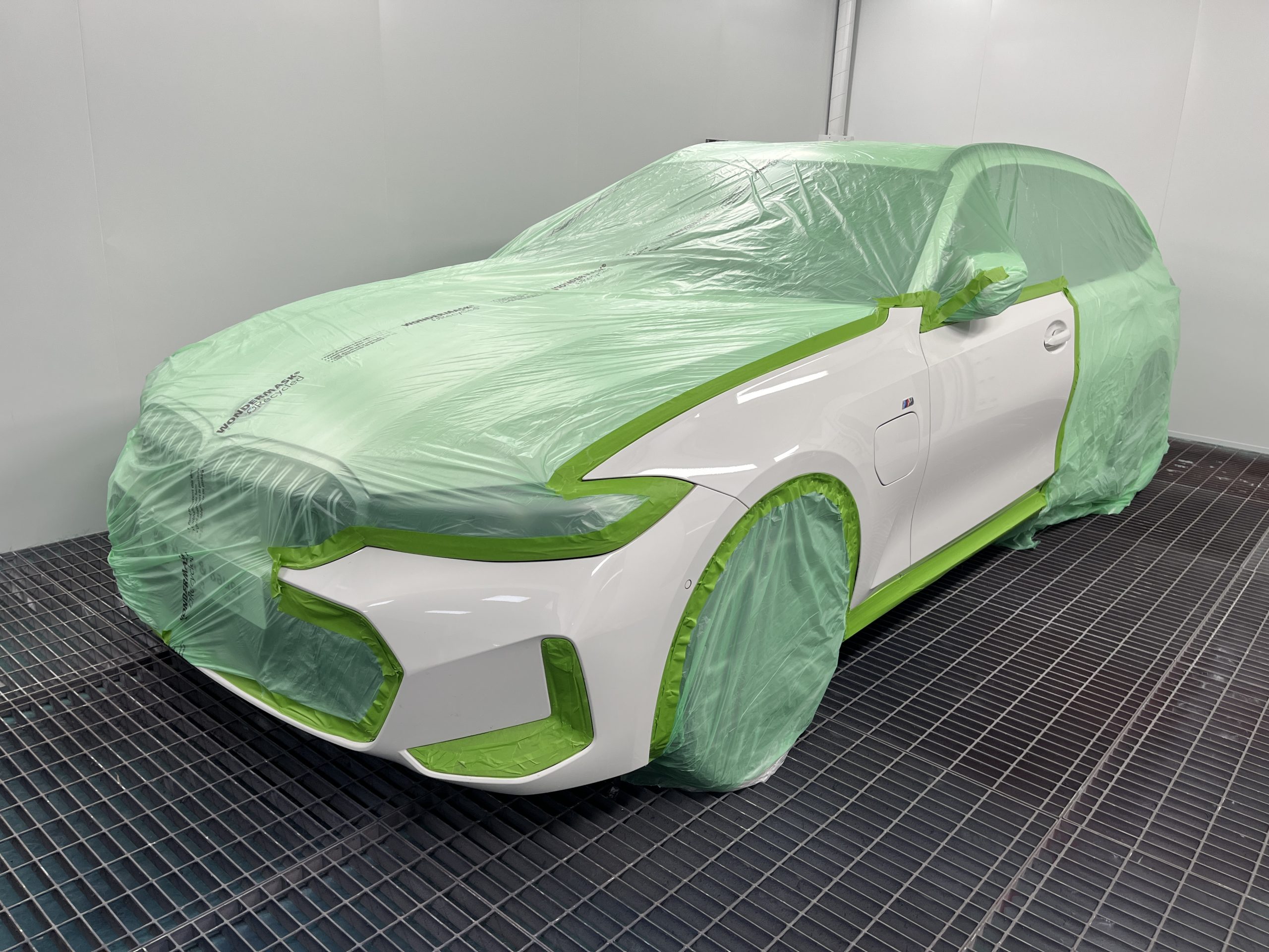 recycled automotive masking film covering white car in spray booth