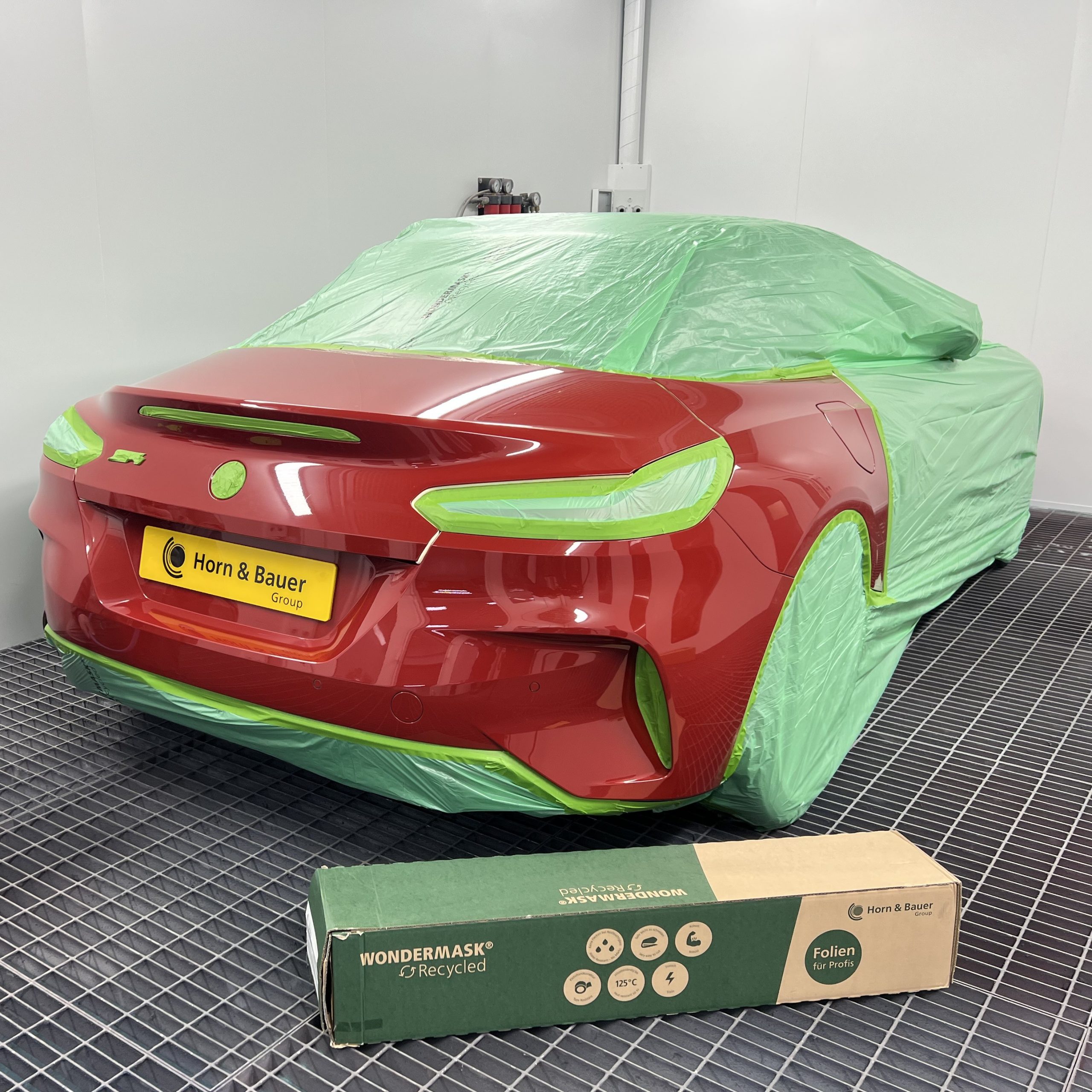 recycled automotive masking film covering car in spray booth